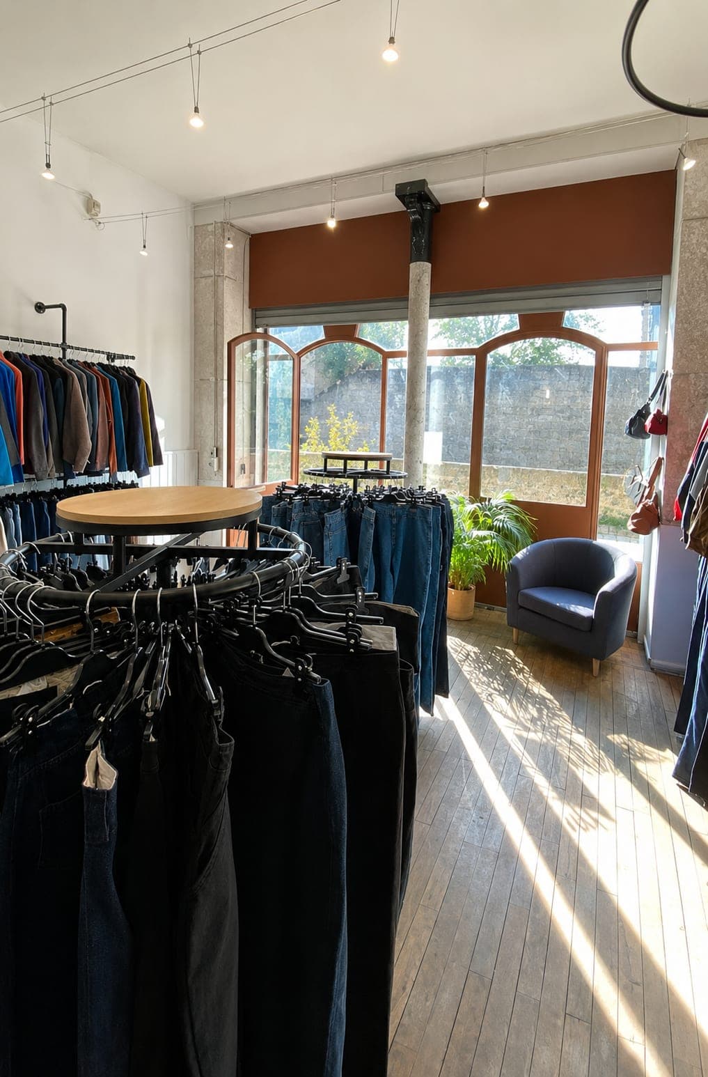 Intérieur lumineux de la boutique Everywear : portants de jeans, denim et coin salon